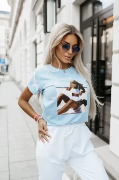 T-SHIRT Z NADRUKIEM KOBIETA NA PLAŻY BŁĘKITNY